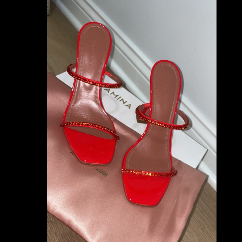 Red metallic leather mules are embellished with tonal crystal trim. Size 38